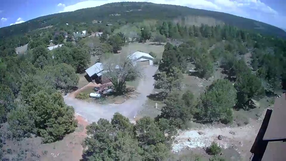 An aerial view of the cabin.  The roof of owners' house is bottom right.
