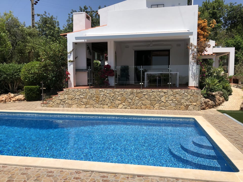 Terrace with glass balustrade, BBQ and pool, with awning shading terrace