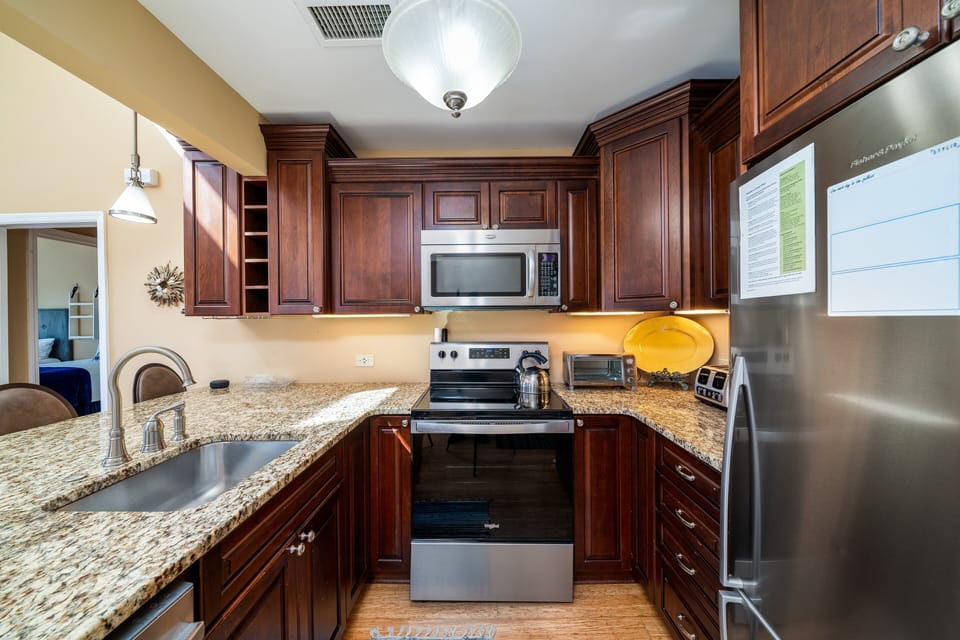 Fully stocked kitchen is updated with granite counter tops,
custom walnut cabinets and stainless appliances.