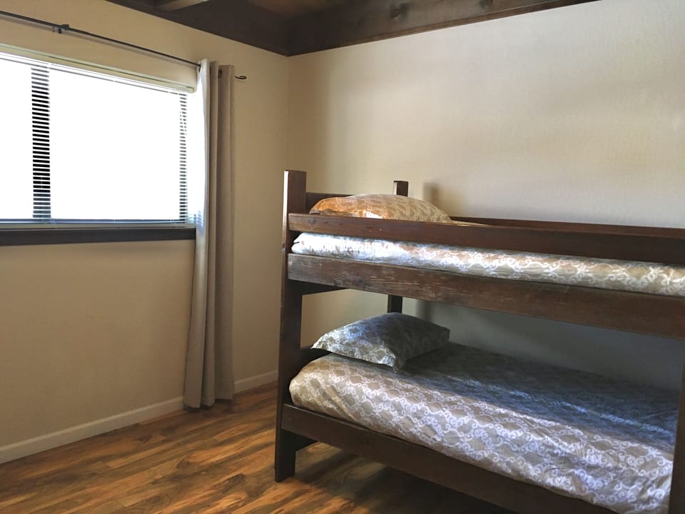 Downstairs bedroom with bunk bed and ceiling fan.