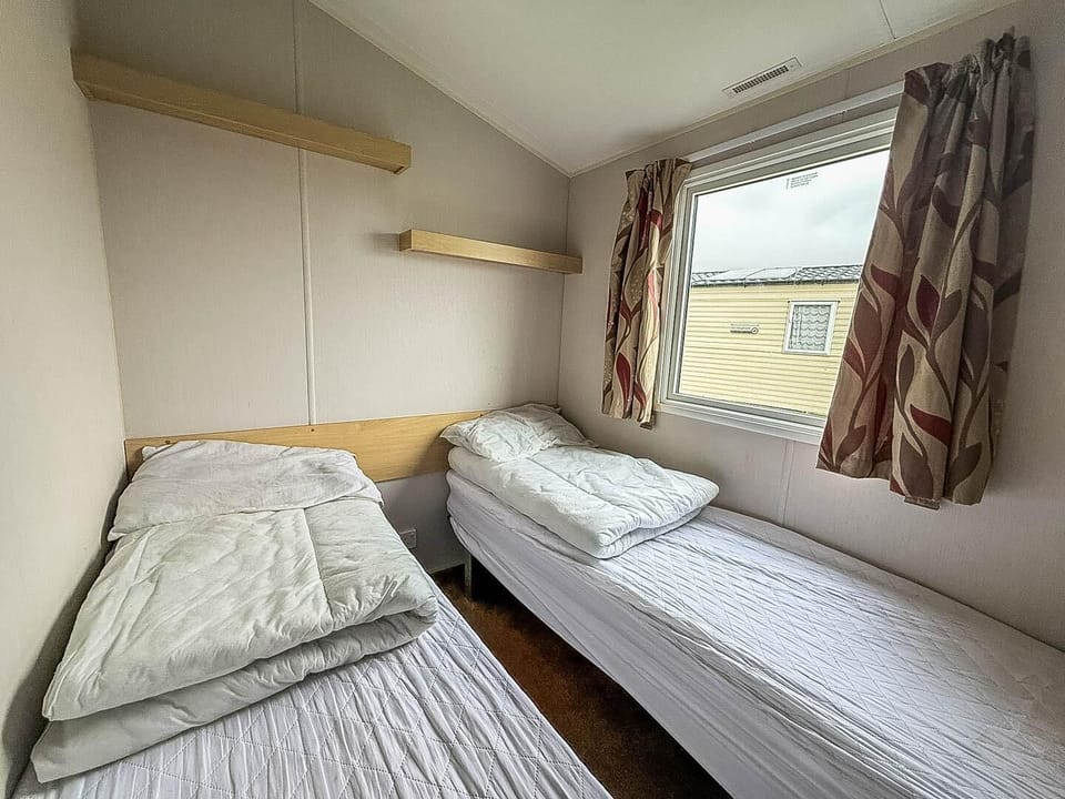 Cozy twin bedroom with natural light and storage shelves
