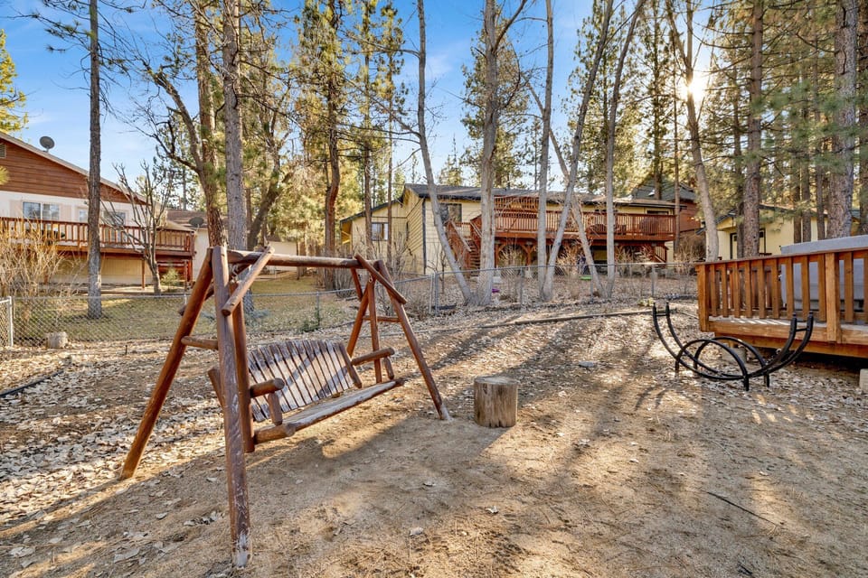 Welcoming cabin entry surrounded by towering pine trees, offering fresh mountain air and a peaceful forest setting—the perfect first impression for your Big Bear Lake getaway.