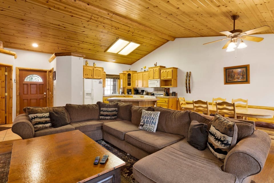 Cozy mountain living room with a stone fireplace, comfy seating, and smart TV—perfect for relaxing evenings, movie nights, and warm cabin vibes after outdoor adventures.