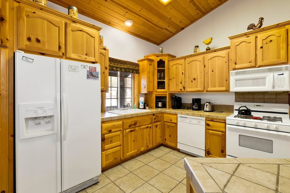 Fully equipped cabin kitchen with ample cabinetry, stove, fridge, microwave, and coffee maker—perfect for cooking meals, morning coffee, and feeling right at home on your stay.