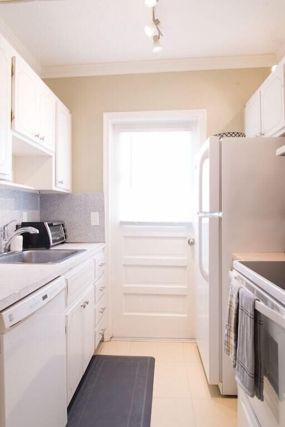Galley kitchen includes full size appliances (fridge, stove, oven, dishwasher).