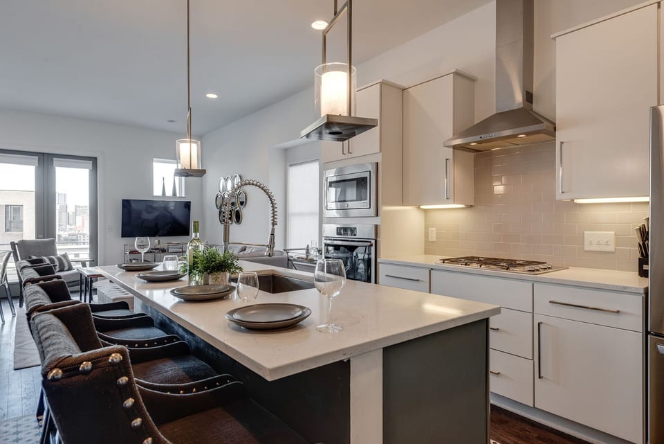 2nd Floor: Fully equipped kitchen, complete with stainless-steel appliances and a kitchen island with ample counter space and bar seating.