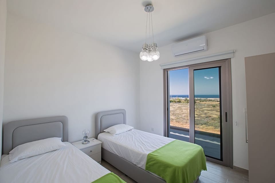 Bedroom 5 with two single beds and balcony access
