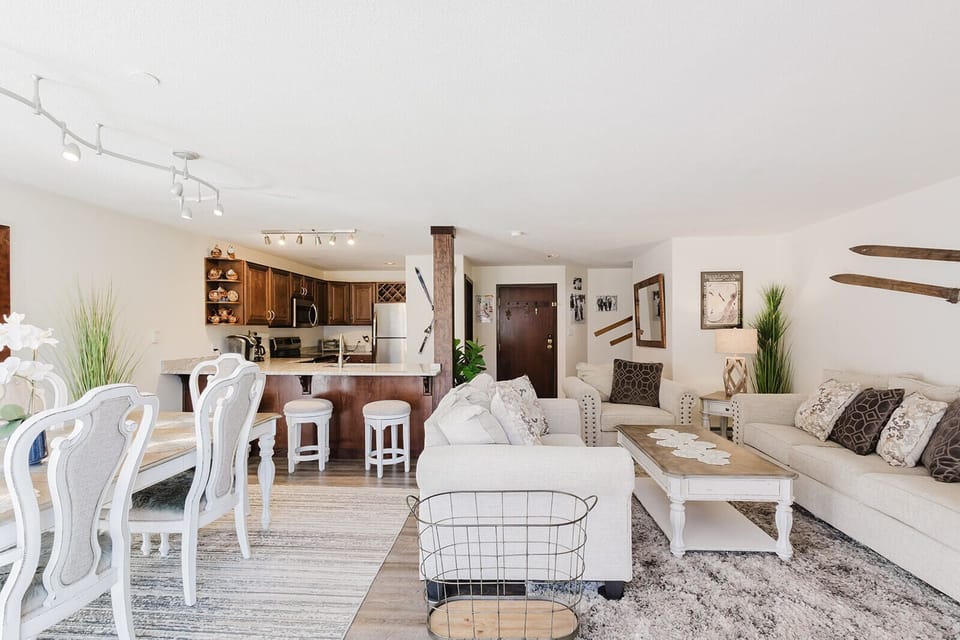 Dining table, living area, and view of the kitchen and foyer.