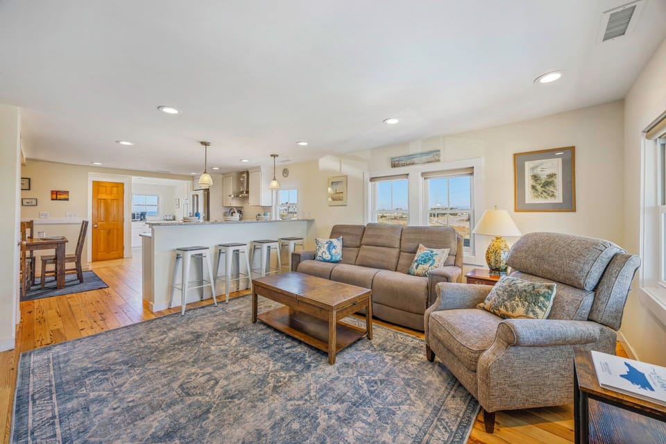 Relax in your spacious open-plan living area with comfortable seating and a modern kitchen featuring breakfast bar seating.
