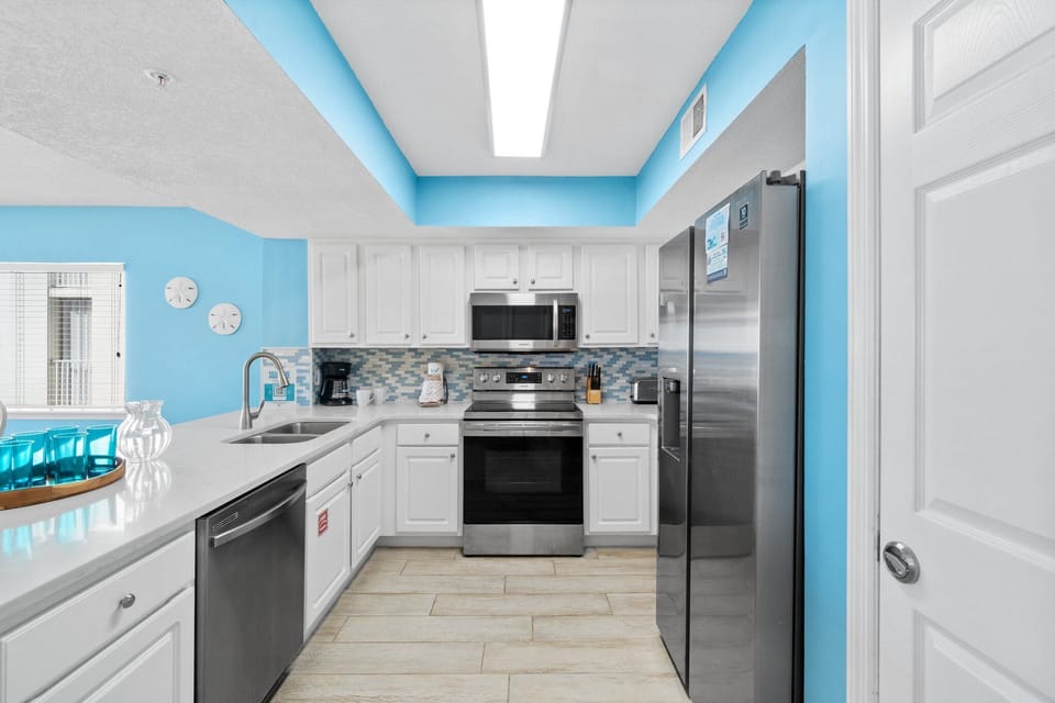 Kitchen - Bright and airy view of the Kitchen enhanced by the Stainless Steel appliances makes meal prepping effortless.