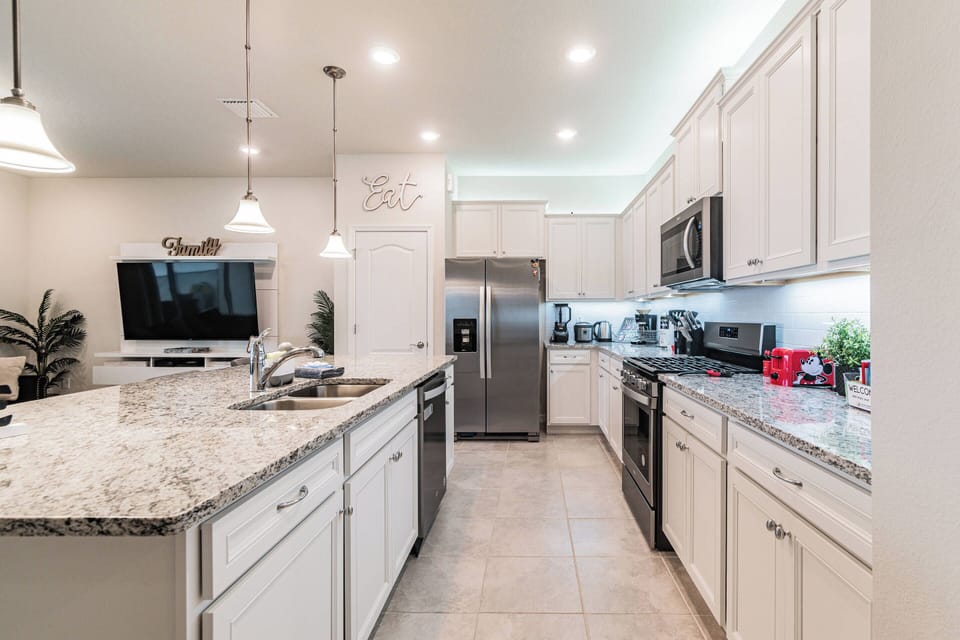 Enjoy a bright kitchen featuring sleek stainless steel appliances and a stunning granite countertop that sparks culinary creativity. Soft white cabinetry and under-cabinet lighting set a warm ambiance perfect for gatherings.