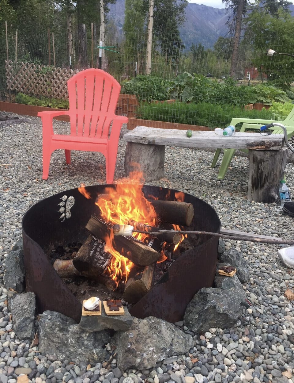 Front yard off to side large fire pit next to garden. 