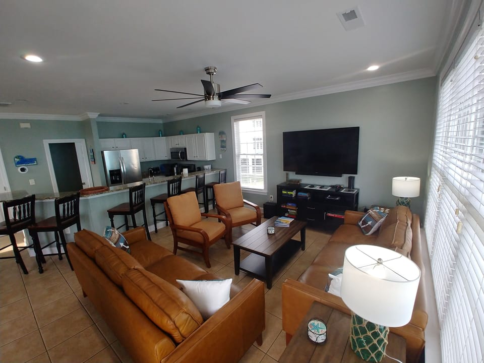 Living room with 72" HDTV accompanied by a Samsung Soundbar audio system.