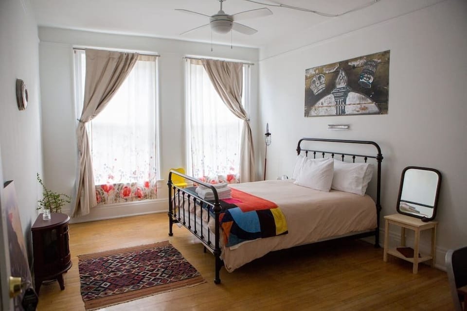 Your Main Street-facing bedroom, outfitted with a queen-size memory foam bed, down pillows and natural fiber linens.