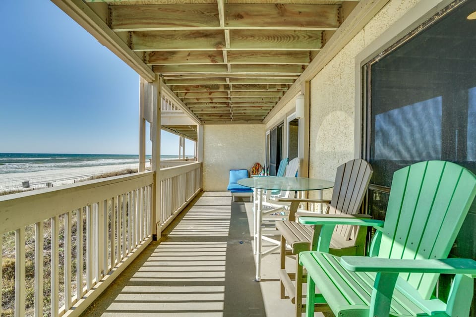 Relax on your private covered balcony with colorful Adirondack chairs and ocean views. Perfect for morning coffee or sunset drinks.