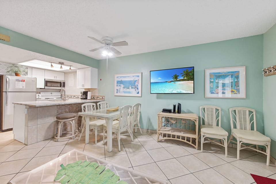 Step into your coastal-inspired living space where soothing seafoam walls create instant vacation vibes while you dine and unwind.