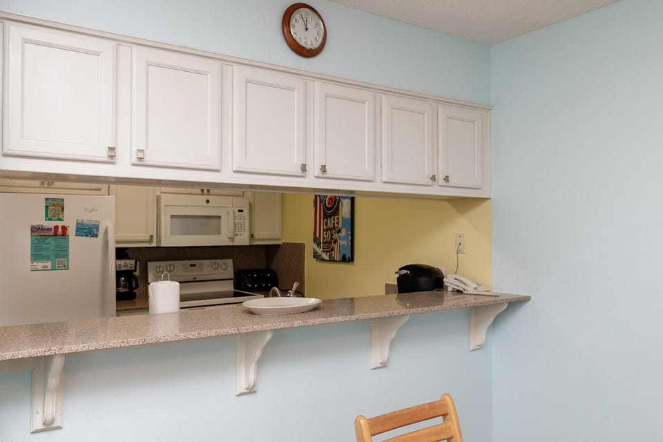 Your fully equipped kitchen features white cabinets, granite counters, and modern appliances to make meal prep effortless during your stay.
