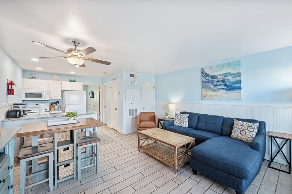 Unwind in your coastal-inspired living space where soft blue tones and ocean artwork create the perfect beachside retreat atmosphere.