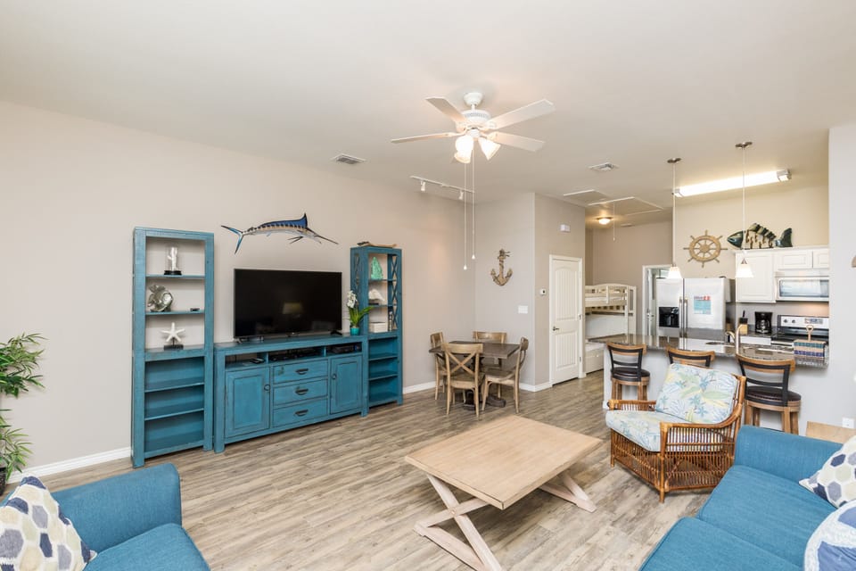 Unwind in your spacious living area with coastal charm, featuring comfortable seating and a fully equipped kitchen for memorable gatherings.