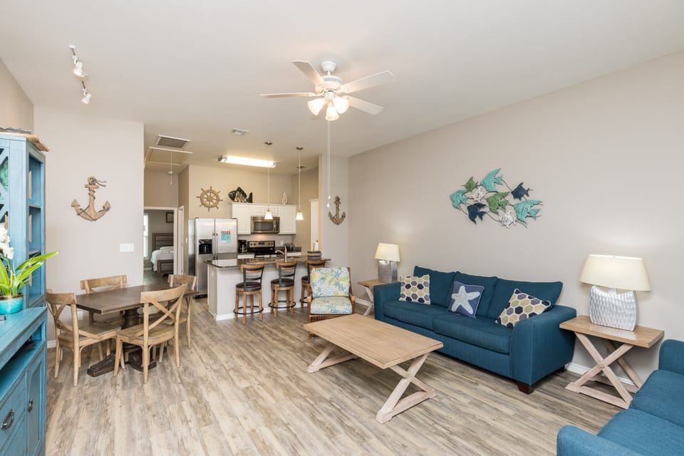 Unwind in your coastal-themed living space with comfortable seating and an open kitchen perfect for gathering.