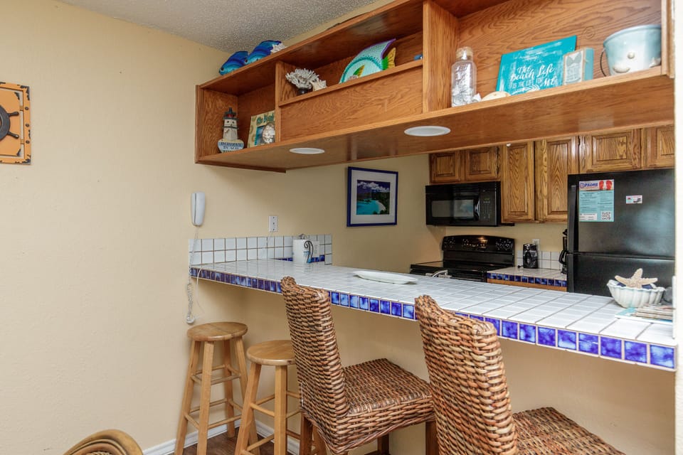 Your coastal kitchen awaits with cheerful blue tile accents, wicker seating, and everything you need for memorable vacation meals.