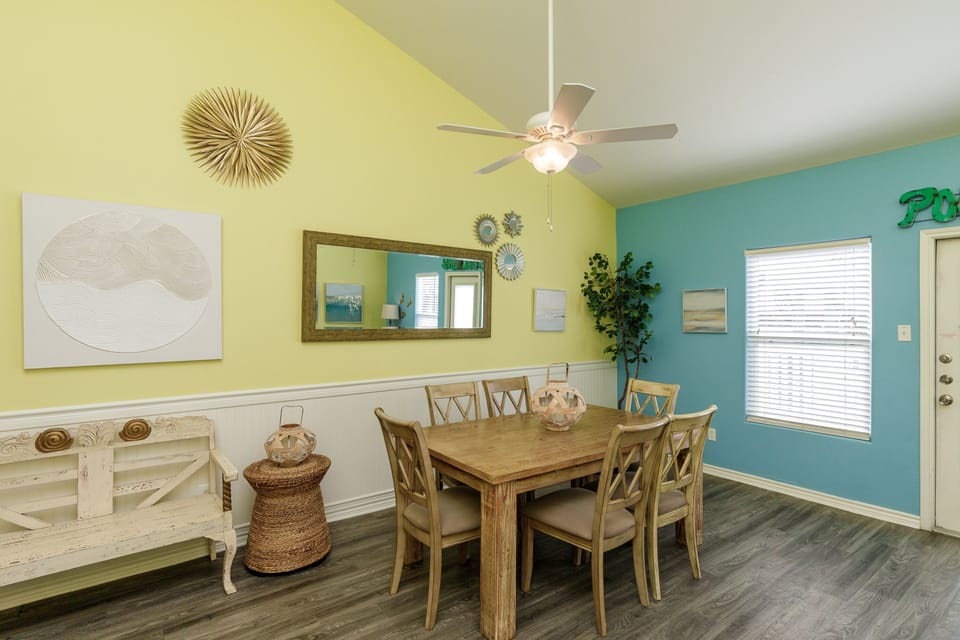 Gather around this bright dining space where cheerful yellow and turquoise walls create a welcoming atmosphere for your family meals and conversations.