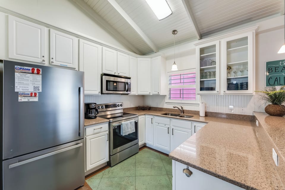 Prepare your favorite meals in this fully-equipped kitchen with stainless steel appliances, granite countertops, and charming coastal details.