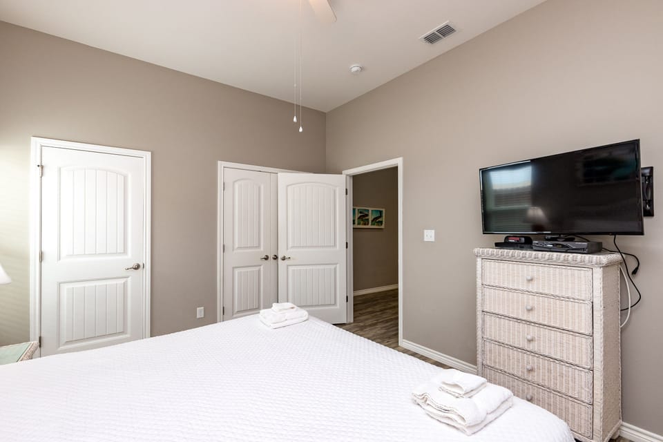 Unwind in your peaceful bedroom featuring a comfortable bed, modern TV, and thoughtful furnishings designed for ultimate relaxation.