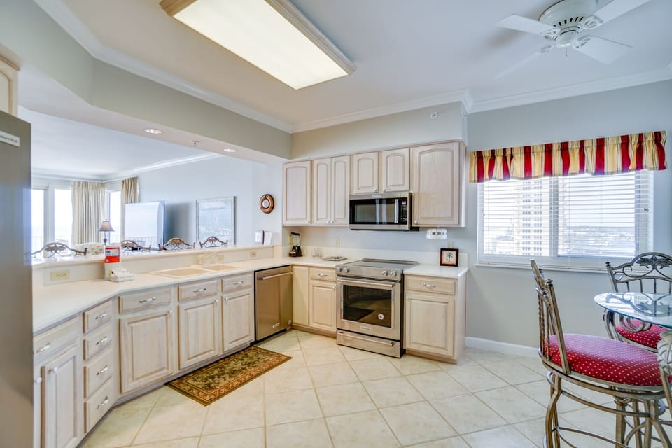 Your fully equipped kitchen awaits with granite counters, stainless appliances, and city views through bright windows.