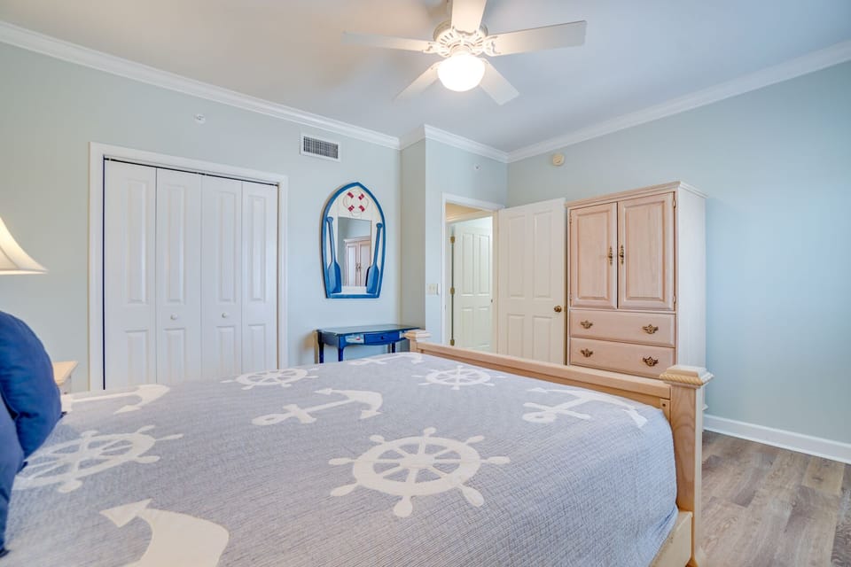 Drift off in your nautical-themed bedroom featuring soft blue walls, anchor-patterned bedding, and charming boat mirror.