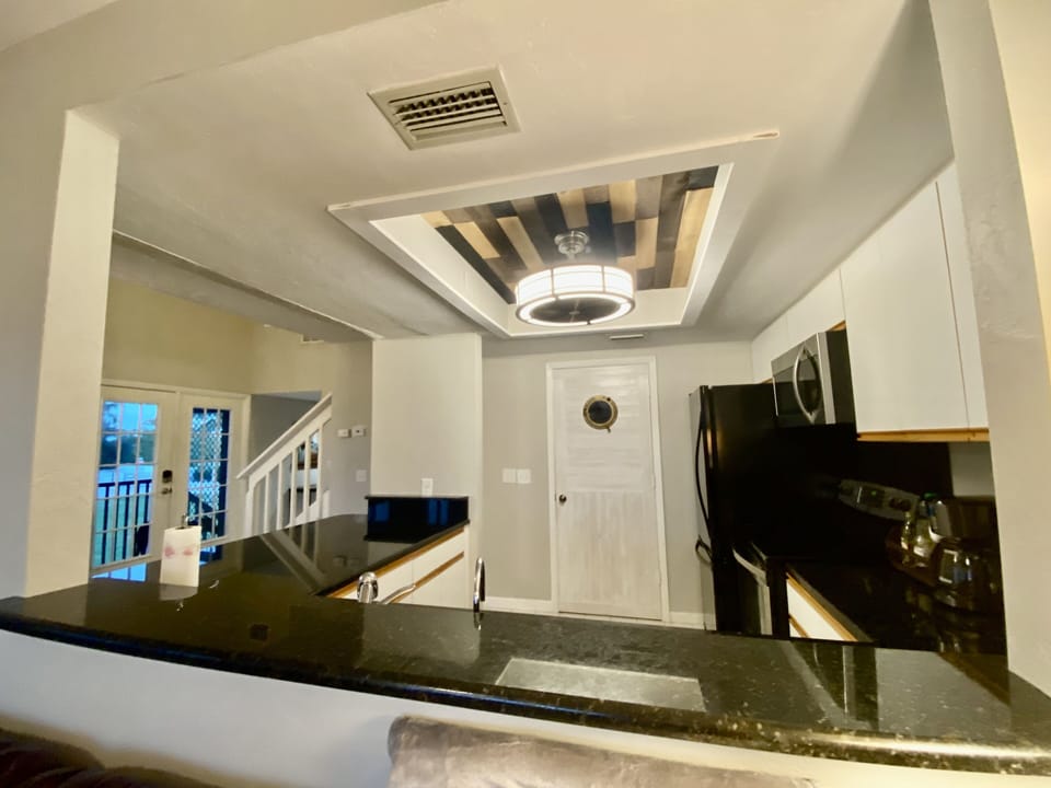 Door into pantry from kitchen with large front load washer & dryer
