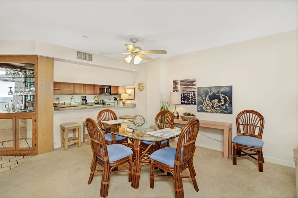 Your open dining space flows seamlessly into the kitchen, perfect for memorable meals with coastal artwork adorning the walls.