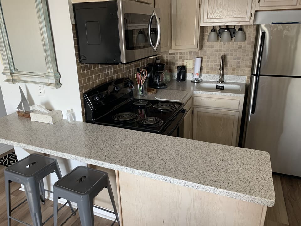 Fully stocked kitchen with breakfast bar seating.