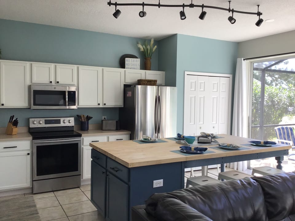 Eat-in kitchen with updated appliances and large sliding doors to the pool.
