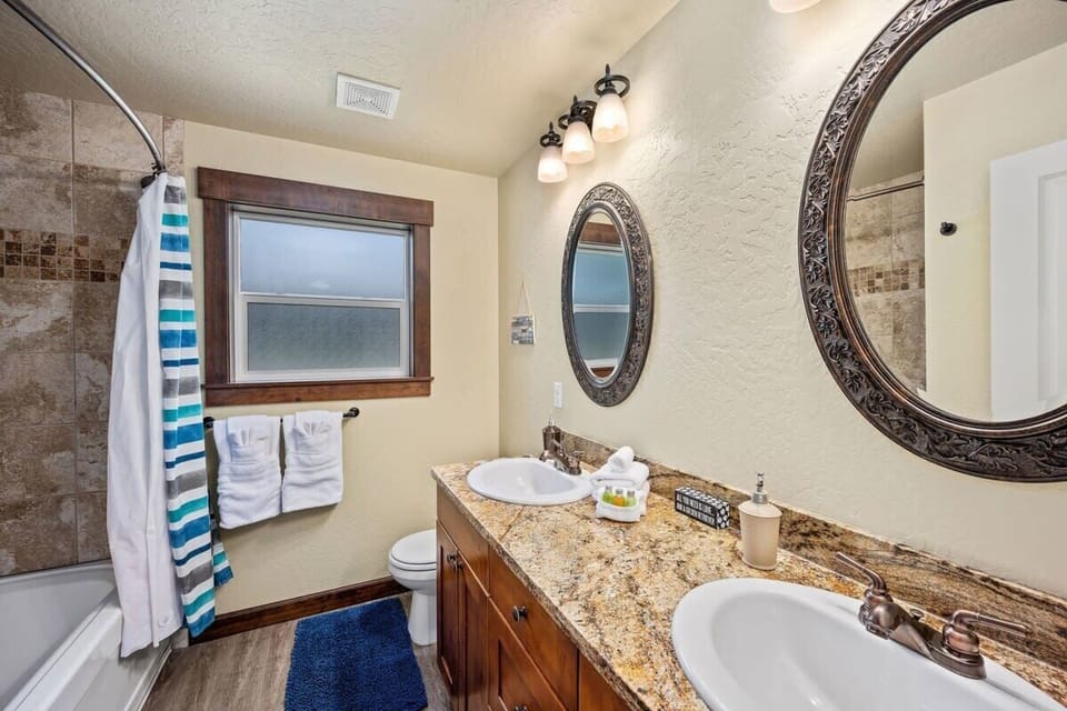 Step into your elegantly appointed bathroom featuring dual vanities, granite countertops, and thoughtful touches like plush towels awaiting your arrival.