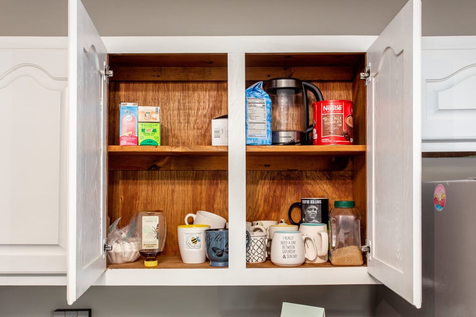 Unique coffee cups, electric kettle, coffee, hot cocoa, tea, and honey/sugar.