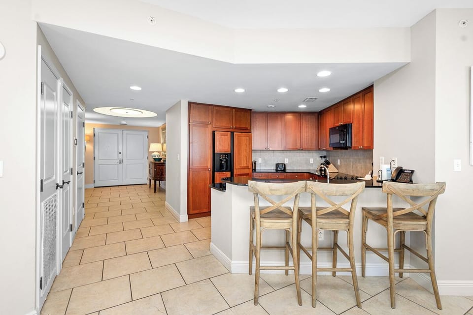 Your home away from home features warm wood cabinetry, modern appliances, and a breakfast bar perfect for morning coffee or casual meals with loved ones.