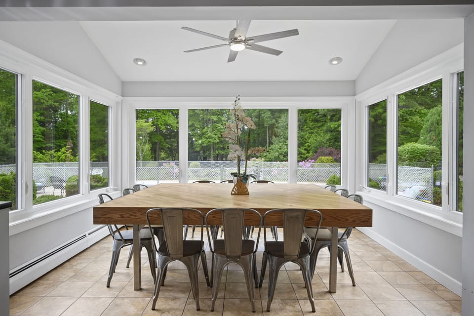 Dining table that seats 14-16 (4 seats on each side) with view of yard and pool 