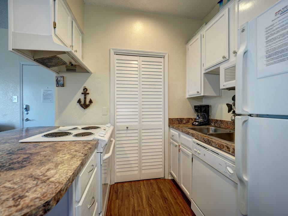 Your fully equipped galley kitchen features granite counters, white appliances, and charming nautical touches for easy meal prep.