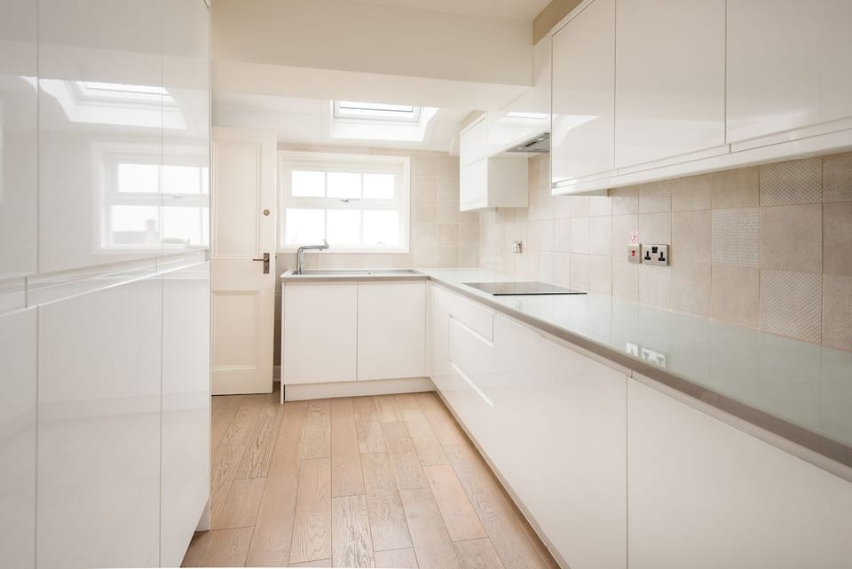 Seaview House - annexe high gloss kitchen with ample storage, sink and induction hob