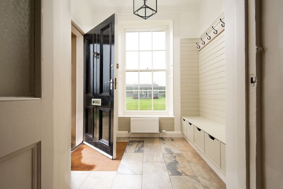 Seaview House - entrance porch / boot room with bench seat and hanging space for outdoor kit