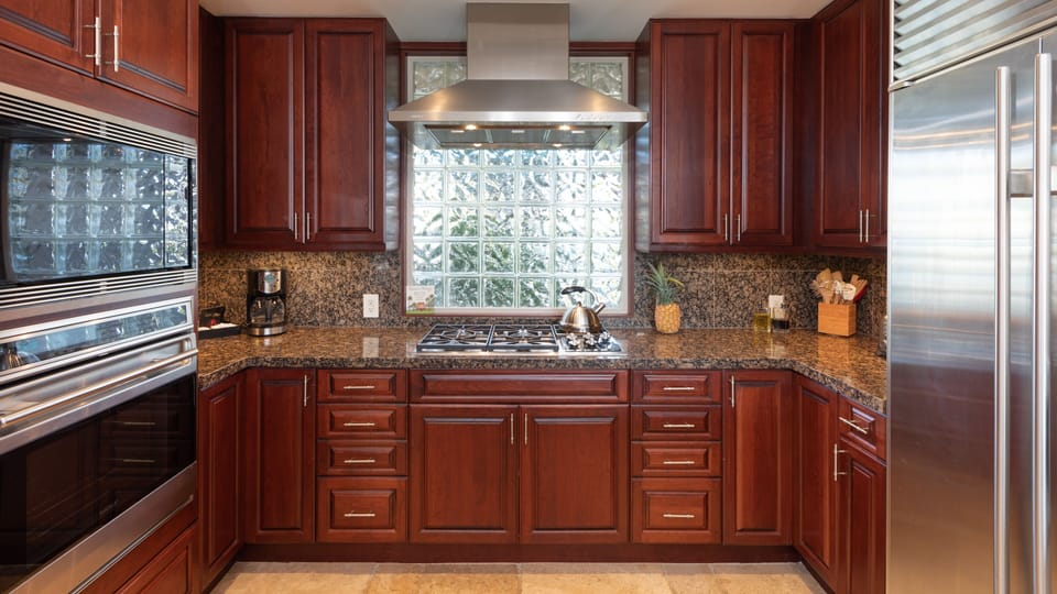 Beautiful dark red wood finishes in kitchen, lots of space for making delicious island inspired meals