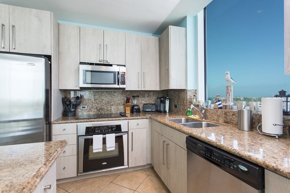 Kitchen with stainless steel appliances. A large kitchen window provides views of the bay!