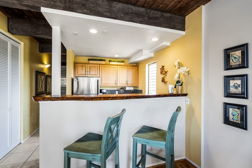 Breakfast bar for two connects kitchen and living space.