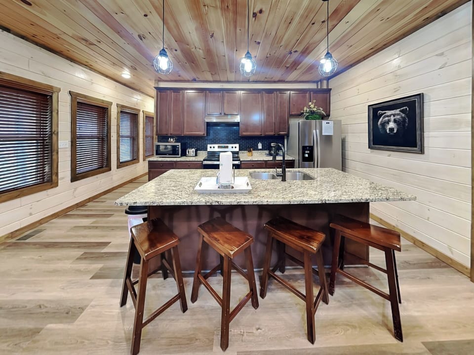 Fully Equipped Kitchen with Stainless Steel Appliances and Breakfast Bar Seating for Four