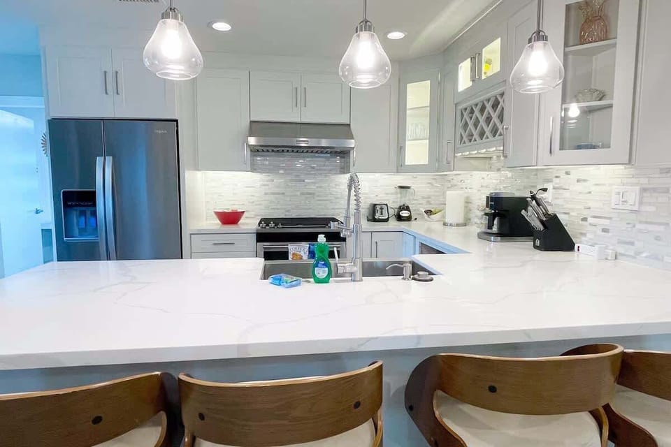 Soft LED illuminating cabinet with fully equipped cooking facilities in kitchen.