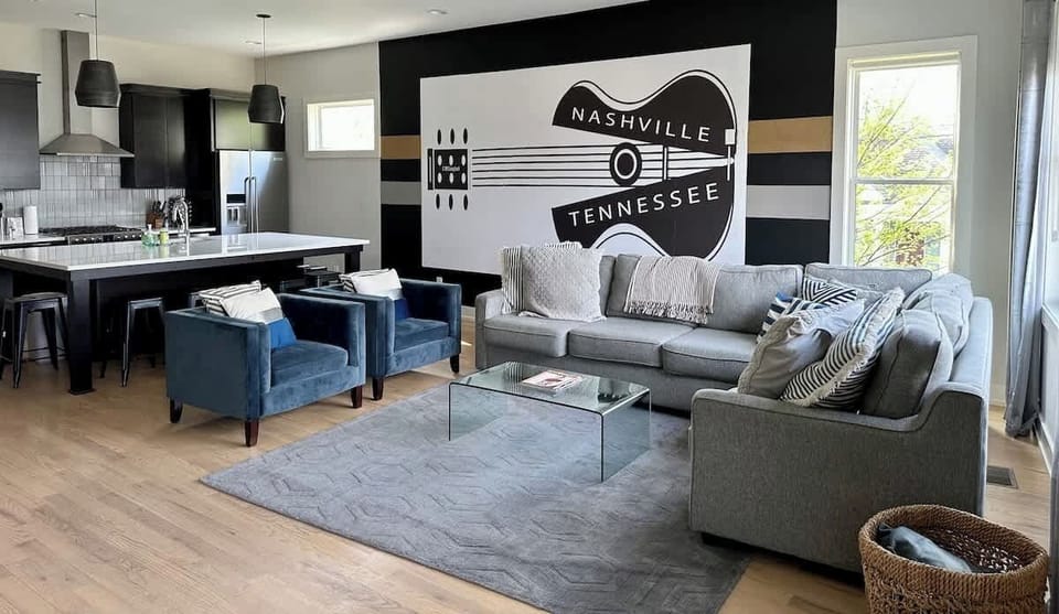 Light Filled Living Room with amazing artwork, oversized custom made sectional sofa, and plush arm chairs. Enjoy a movie on 65" SmartTV