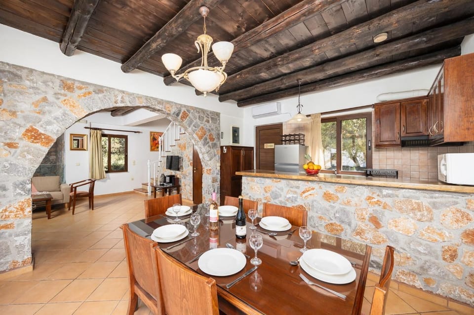 Open-plan living room with sofa, dining area, kitchen, indoor pool, ornamental fireplace, A/C, WiFi internet, and satellite TV