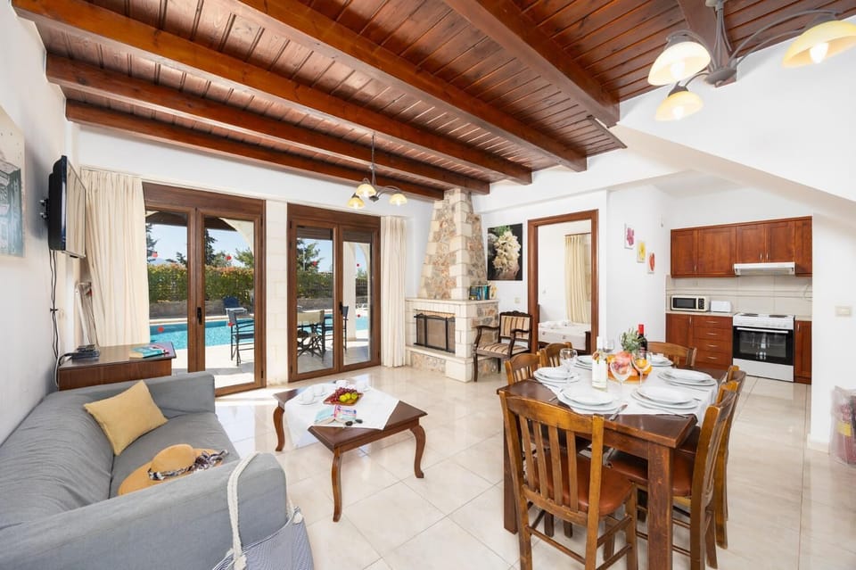 Open-plan living room with sofa, dining area, kitchen, ornamental fireplace, WiFi internet, and satellite TV