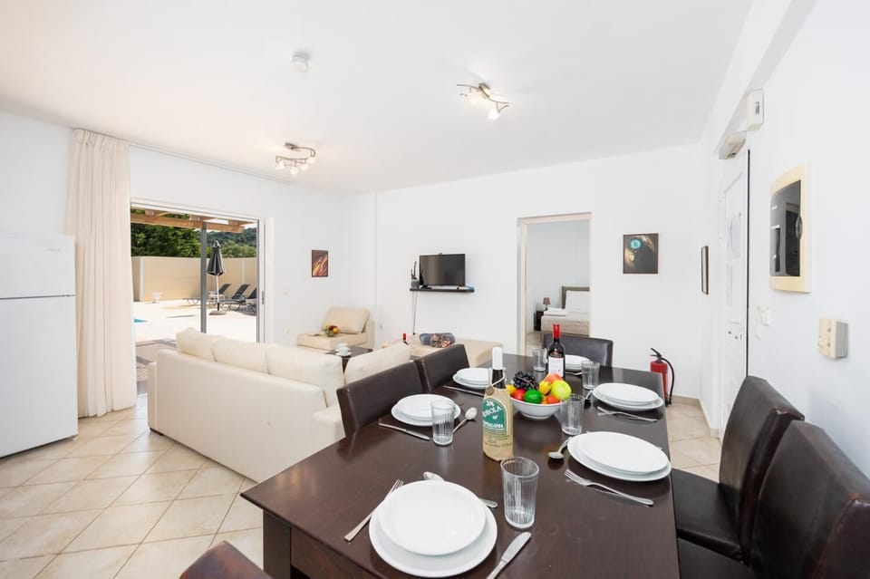 Open-plan living room with sofa, dining area, kitchen, A/C, WiFi internet, and satellite TV